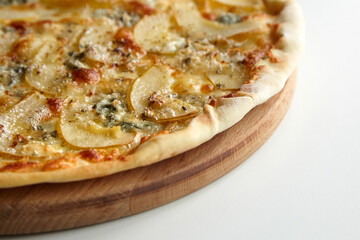 Pizza with cheese and pear fruit on cutting board