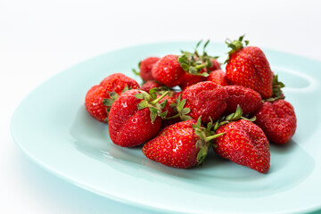 Delicious red strawberries, isolated on a plate. Background texture.