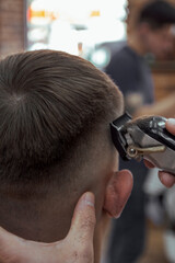 Barber making a haircut with a hair clipper