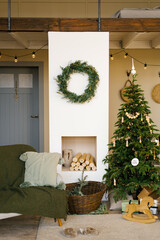 Stylish Christmas decor in a Scandinavian country house in beige tones. Fireplace and Christmas tree in the living room