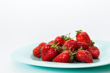 Red strawberries on a plate. Isolated on a white background.