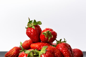 Strawberries in a black plate. Isolated on a white background.