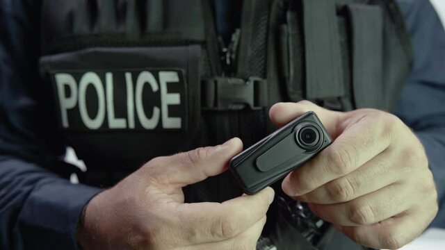 two hands on police body camera