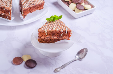 Chocolate bisquit cake with icing on a plate
