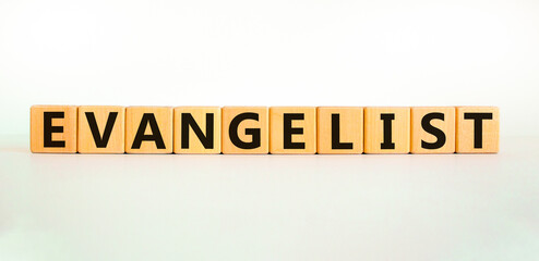 Evangelist symbol. The word Evangelist on wooden cubes. Beautiful white table, white background....