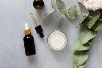 Beauty concept serum and jar with cream and eucalyptus