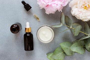 Obraz na płótnie Canvas Beauty concept serum and jar with cream and eucalyptus