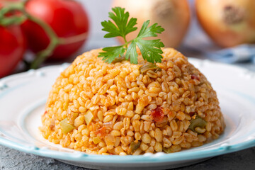 Traditional turkish bulgur pilaf with tomato sause in plate (Turkish name; meyhane pilavi)
