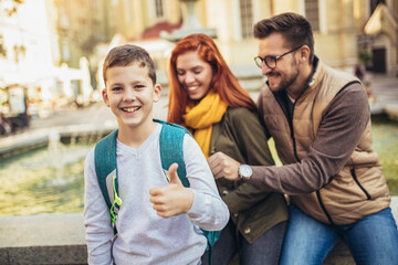 Young parents taking their little child to school