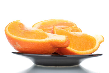 Three slices of organic ripe minneola on a ceramic dish, close-up, isolated on white.