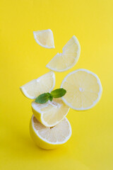 Pyramid of chopped lemon in balance on the yellow background. Location vertical.