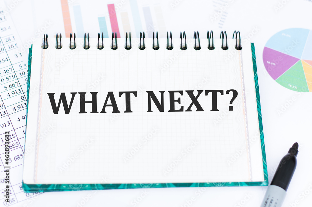 Aufkleber what's next text on a blank notebook that lies on the table next to color charts