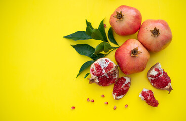 three juicy and ripe pomegranates on yellow background. Fruits contain many vitamins. healthy fruits:  good for healthy lifestyle.  food for diet. jewish holiday