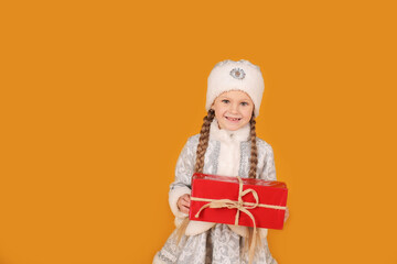 маленькая красивая девочка блондинка с косичками в национальном новогоднем костюме снегурочка держит в руках подарочную коробку