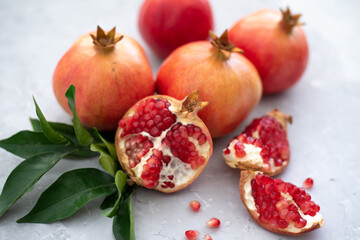 Three large juicy and ripe pomegranates on grey background. Fruits contain many vitamins. Fresh fruits:  good for healthy lifestyle.  food for diet. jewish holiday