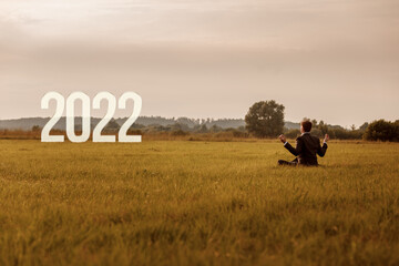Businessman meditates on the background of the new 2022.