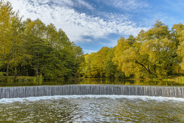 Artificial waterfall in the Drozdy Forest Park in Minsk, Belarus. Autumn landscape.
