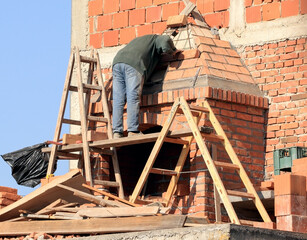 An experienced ladder worker monitors the interior  works of the chimney