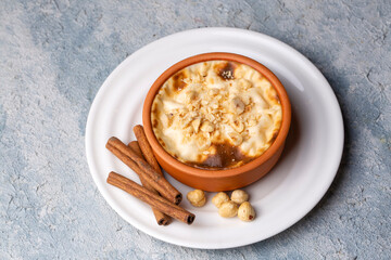 Baked rice pudding turkish milky dessert sutlac in earthenware casserole with hazelnuts