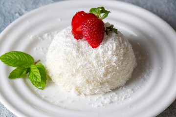 Delicious milk dessert; cup dessert with coconut and strawberry (Turkish name; fincan tatlisi