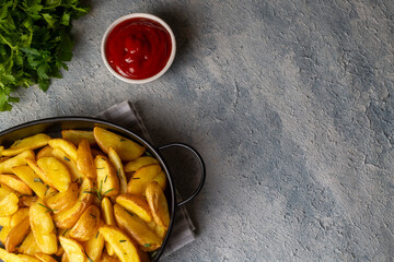 Roasted potato wedges with herbs and sea salt on plate, top view (Turkish name; elma dilim patates)