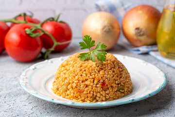 Traditional turkish bulgur pilaf with tomato sause in plate (Turkish name; meyhane pilavi)