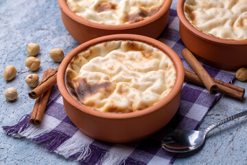 Baked rice pudding turkish milky dessert sutlac in earthenware casserole with hazelnuts