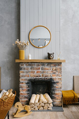 Scandinavian brick fireplace with wood and decor on it against the background of a gray wall of a...