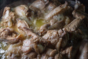 Chicken wings are cooked in their own juice in a pan
