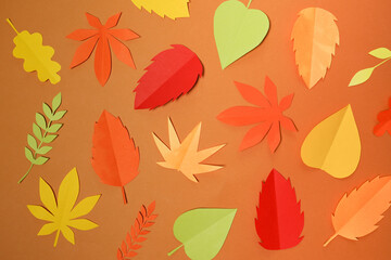 Fototapeta na wymiar autumn paper leaves fall on orange background. Handmade origami.