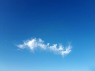 Naklejka na ściany i meble Little white fluffy cloud on clear blue sky, can be used as background