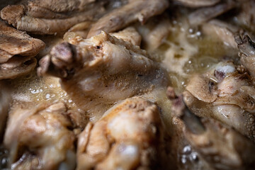 Chicken wings are cooked in their own juice in a pan