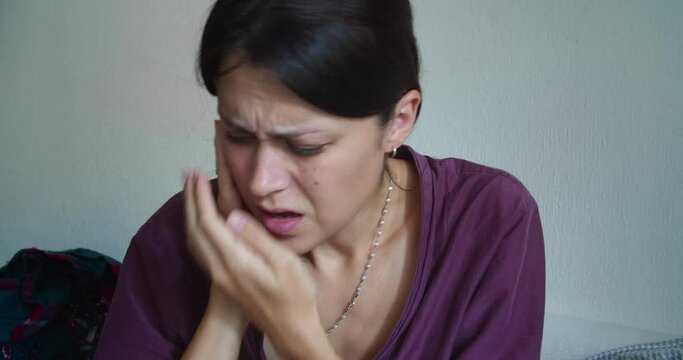 Sick woman in robe at home with sharp sore throat with viral flu. Sadness illness female adult with ear pain at home in quarantine. Covid sympthoms in cold season. Indoor cold and flu hurts to swallow
