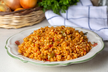 Traditional turkish bulgur pilaf with tomato sause in plate (Turkish name; meyhane pilavi)