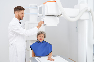 Front view of grey haired woman smiling, sitting at cabinet of ultra diagnostic, smiling at camera....