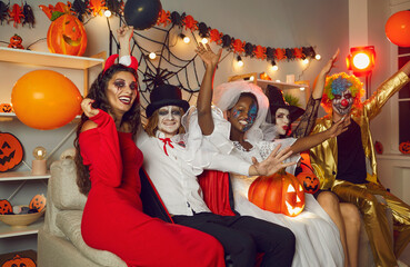 Happy friends disguised as crazy evil monsters having fun at Halloween party. Adult people with...