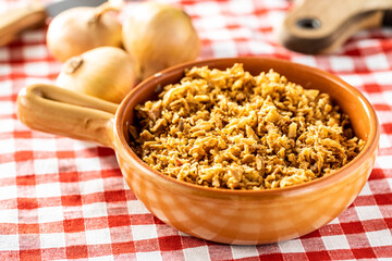 Pieces of fried onions in bowl.
