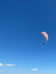 Skydiver flies under the canopy of a parachute, quickly approaching, close-up
