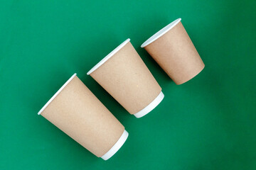 empty paper cup to go against green background
