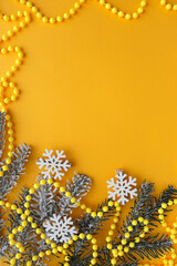 christmas card mockup. frame from fir branches of snowflakes and Christmas tree decorations on a yellow background. invitation. congratulation 