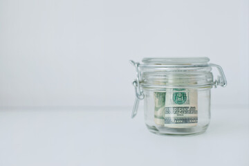 cash dollars money in a glass jar