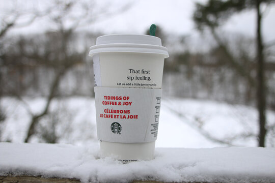 LONDON, CANADA - Jan 01, 2021: Starbucks holiday cup in a snowy cold forest