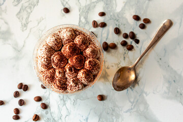 Perfect freshly made Italian tiramisu with cacao. Tiramisu portion on a white marble background....