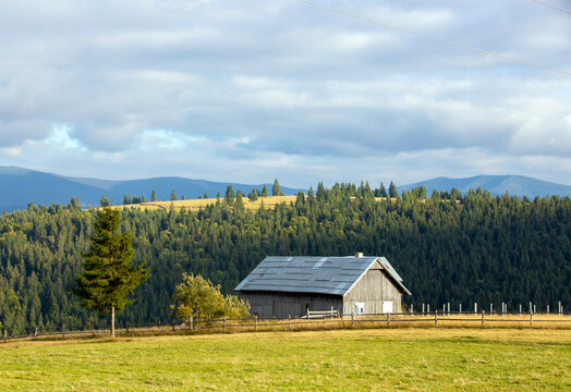 a beautiful landscape with an old wooden cottage on a mountain top