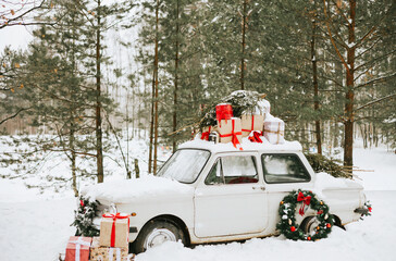 retro car decorated for Christmas with gifts among the winter forest, concept of Christmas, New Year celebration and winter holidays - obrazy, fototapety, plakaty