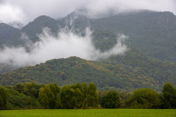 landscape with fluffy clouds on the mountain tops