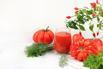 Tomato juice and ingredients on a bright sunny table. Detox diet and weight loss concept, natural nutrition, healthy and wholesome food. Summer drinks, vitamin C, selective focus, place for text