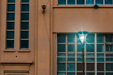 Front view of a lit lantern of the street digitally lighted up and the facade of a old building as backgrounds