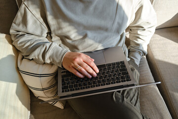 A man works with a laptop and smartphone at home or in hotels. Remote work. Office at home. A man is typing on a laptop, distance learning for students, surfing the Internet. Business concept