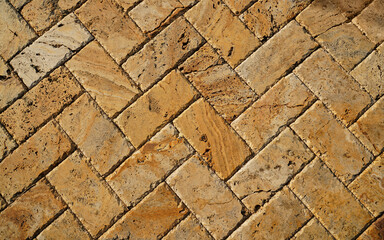 Yellow brown stone pavers background. Neutral texture of a flat brick wall close-up.        